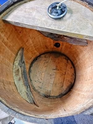 Inside a barrel owl box showing the curved inside perches and the camera on the lid