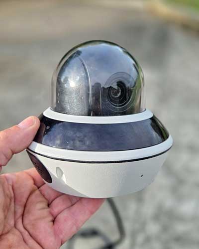 A Hikvision mini PTZ camera held in the hand