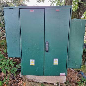 A green weatherproof outdoor cabinet that houses the wildlife camera streaming equipment